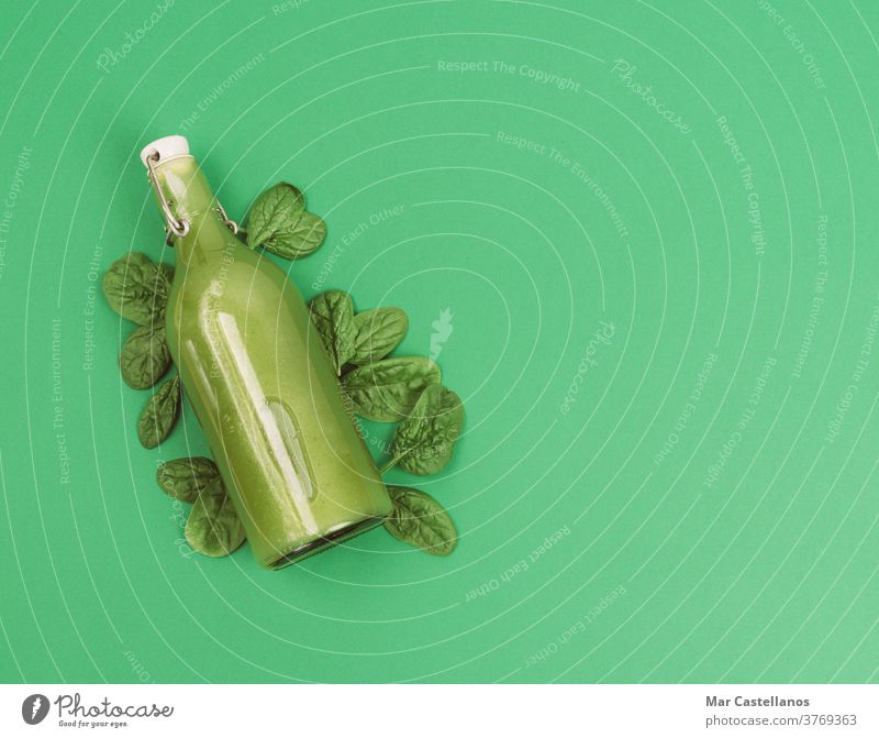Bottle of spinach juice. Copy space. bottle vegetarian vegan vegetables fruits apple ginger celery leaves healthy purifying green background copy space full