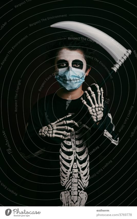 Happy Halloween,kid with medical mask in a skeleton costume with a scythe child halloween coronavirus covid-19 party fun skull fear social distancing scary dead