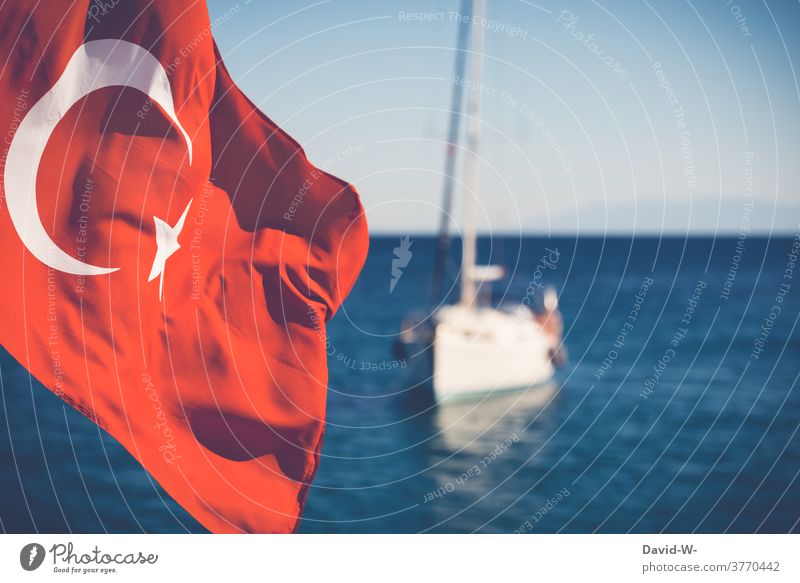 A Turkish flag is waving in the wind - a boat is floating on the sea in the background turkey Flag vacation ocean Ocean holiday destination Vacation & Travel