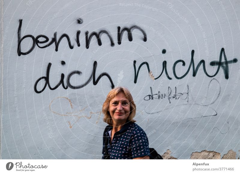 Motto of the week: Don't behave! Wall (building) Woman Face of a woman Human being Adults Colour photo Wall (barrier) Feminine Exterior shot portrait Day