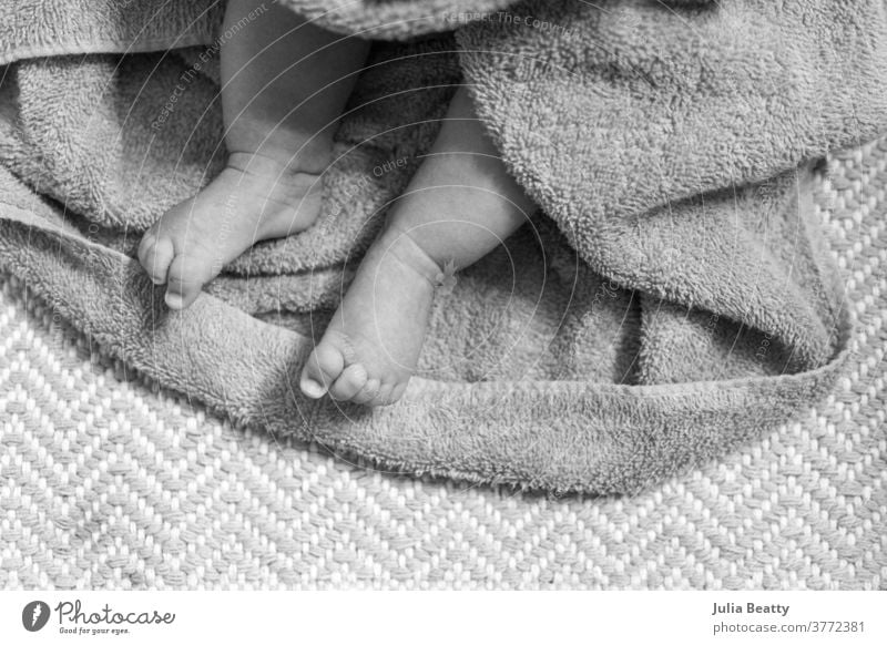 clean newborn baby; feet wrapped in towel after a bath Bath dry zig zag bath time infant child 0 - 12 months infancy childhood small cute relaxed candid quiet