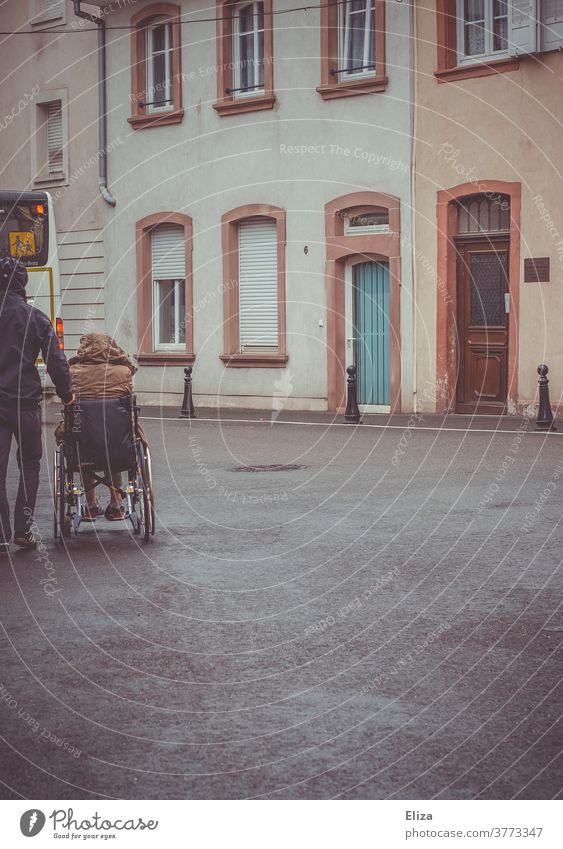 A man pushes a disabled person in a wheelchair Wheelchair handicap Mobility Health care Rainy weather Illness Trip Push walking impediment Handicapped Inclusion