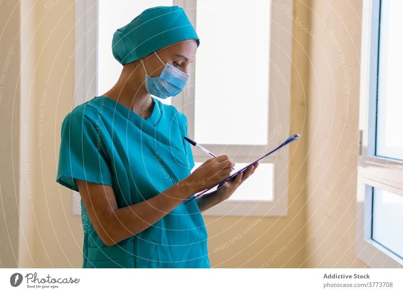 Nurse writing on clipboard in hospital nurse write take note medic woman clinic work medical young female professional medicine occupation staff health care