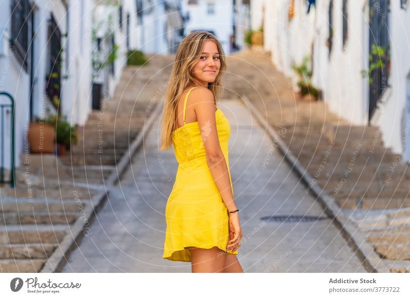 Smiling woman in yellow dress in city charming summer street enjoy urban culture travel female tourism tourist traveler town holiday smile vacation young style