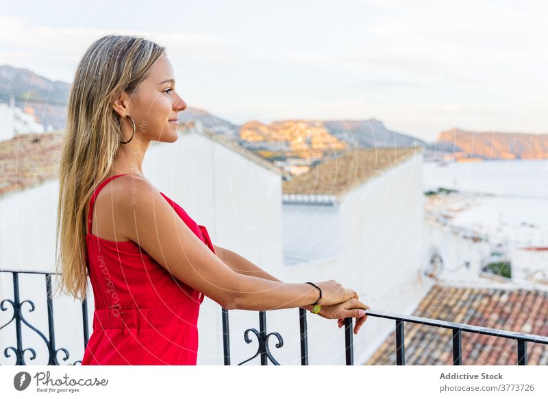 Content woman on balcony in old city tourist terrace cityscape admire observe summer enjoy smile female railing amazing lean rest vacation sunset tourism stand