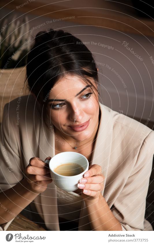 Calm woman enjoying hot coffee at home drink relax dream rest cup positive break young female beverage lifestyle comfort calm cozy pleasure pensive content