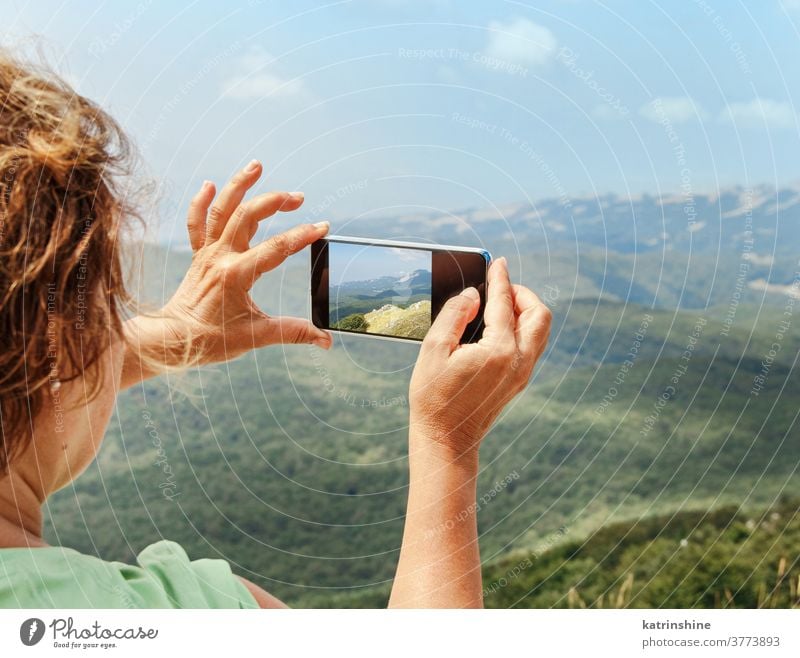 Woman taking photos with mobile phone in mountains woman hiking nature outdoor acivity Recreation close up Person Travel Challenge Effort Healthy Tourist