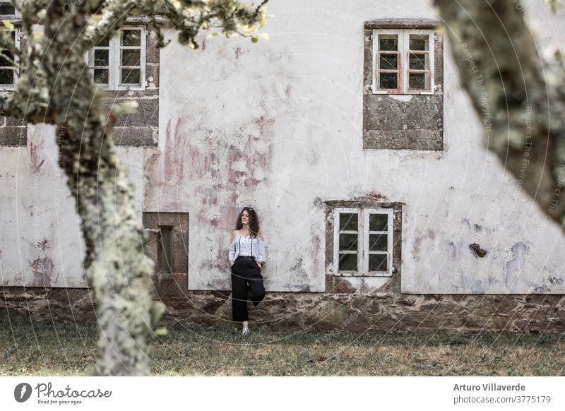 Woman girl leaning on the facade of an old building with the white wall and some classic windows summer house woman caucasian rest freedom autumn wooden