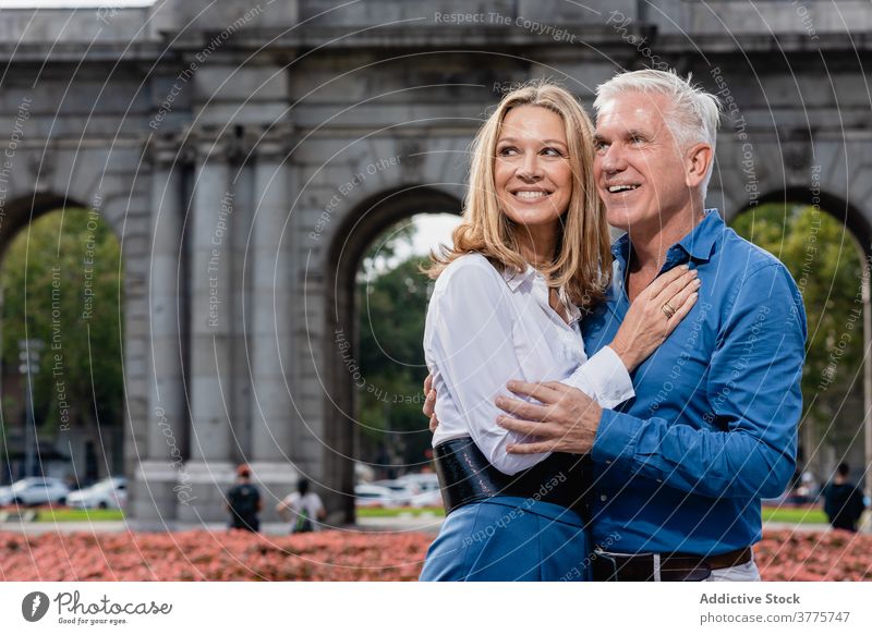 Happy mature couple hugging in park urban adult love relationship stroll enjoy embrace summer city happy delight cheerful rest town bonding weekend glad