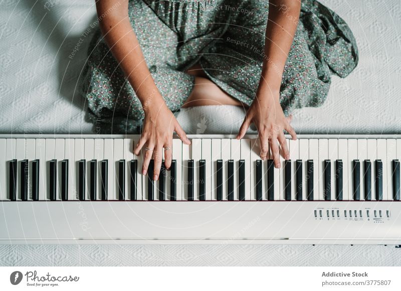 Woman playing piano in living room music musician woman rehearsal talent skill creative melody ethnic modern apartment song perform sound entertain sit relax