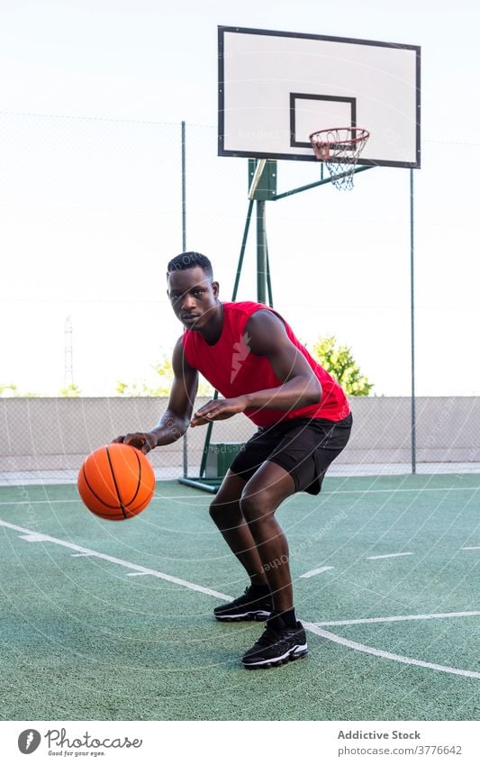 Concentrated black man playing basketball on court player sports ground playground serious tactic focus male african american ethnic modern professional healthy