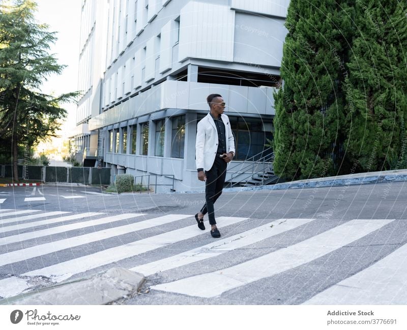 Stylish black businessman crossing road in city crosswalk entrepreneur style classy trendy male ethnic african american outfit manager professional contemporary