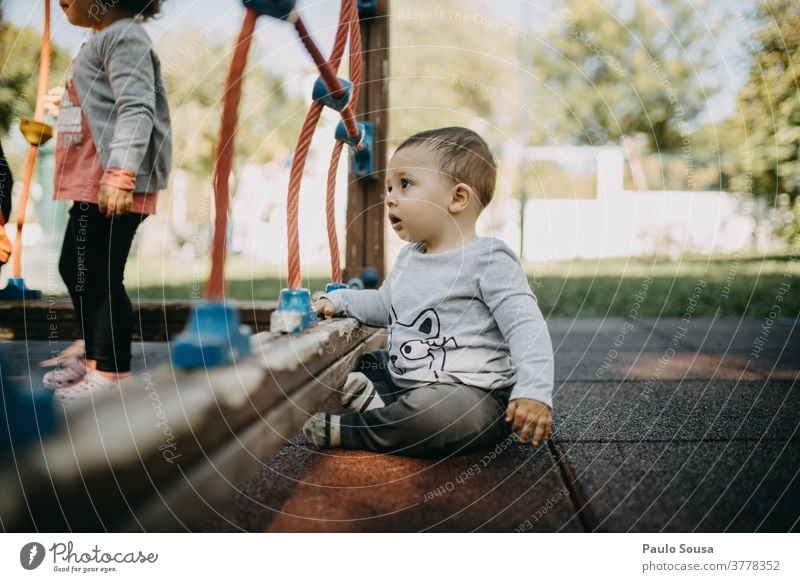 Toddler playing at playground Caucasian Child Kindergarten Playing Playground Park Cute 1 Leisure and hobbies Infancy Exterior shot Joy Colour photo Human being