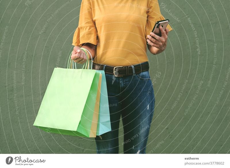 woman holding a shopping bags and smartphone young woman woman shopping shopper smile girl fun funny shopping center commerce shopping girl customer happy