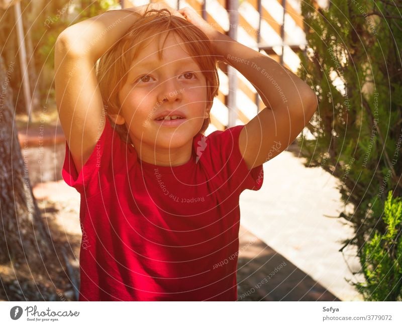 Little boy playing outdoors in summer lifestyle child authentic kid backyard freedom nature face smiling sun fun little portrait cute joy blonde sunlight