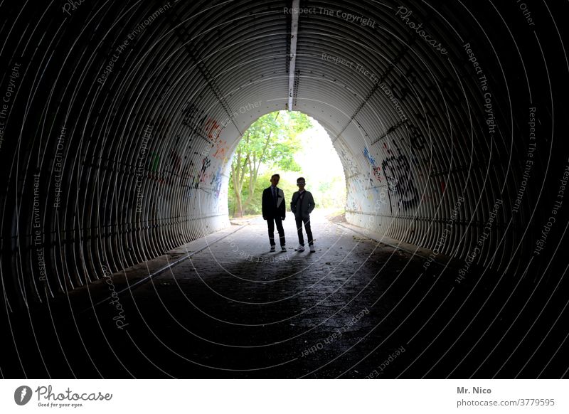 Silhouette of two young people in an underpass Tunnel Light Dark Graffiti Shadow Contrast Manmade structures Architecture Underpass Lanes & trails Pedestrian