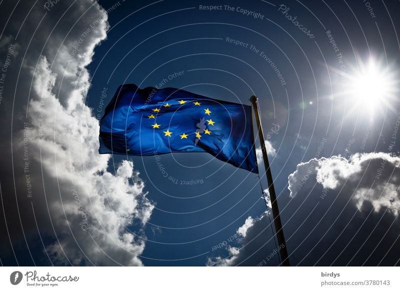 European flag in the backlight, dramatic clouds and sunshine.Europe Sun Wind Clouds Dynamics Blow martial Blue Yellow Back-light Illuminate Translucent