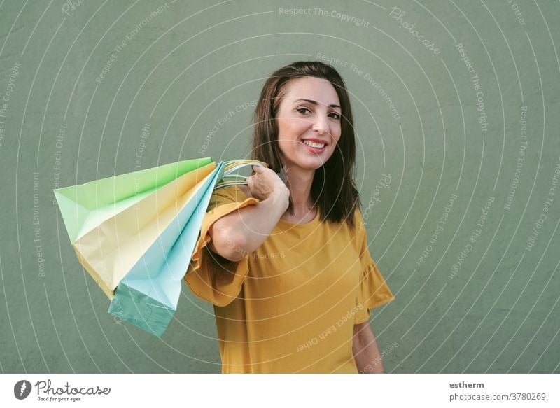 smiling young woman holding a shopping bags woman shopping shopper smile girl fun funny shopping center commerce shopping girl customer happy purchase lifestyle
