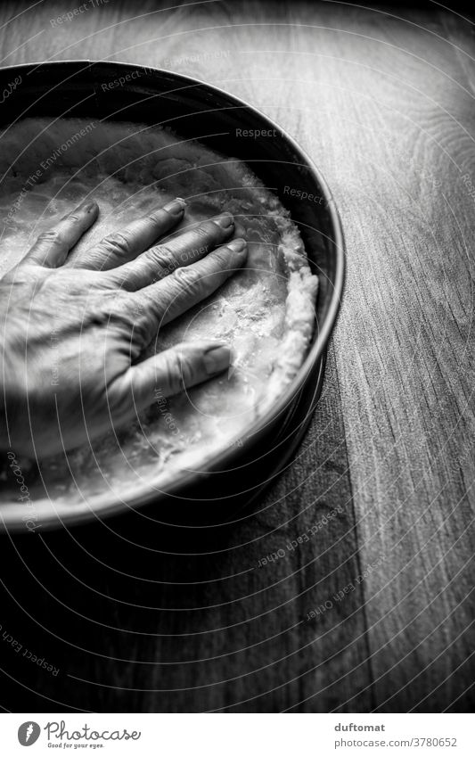 Black and white picture of a hand kneading the cake dough into a springform pan. Baking Black & white photo Cake Gateau Patisserie Baked goods Rustic