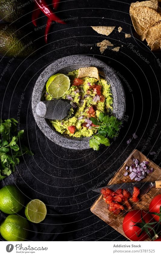 Appetizing guacamole in bowl on table avocado tasty dish vegetable vegetarian serve delicious tomato lime fresh parsley food organic herb ingredient cuisine