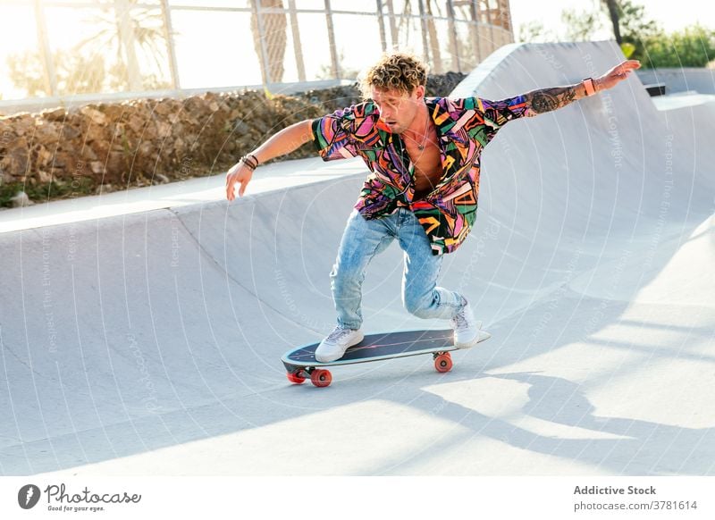 Active hipster man skateboarding in park skater ramp skatepark style activity trick ride trendy young male stunt skill lifestyle modern millennial funky active