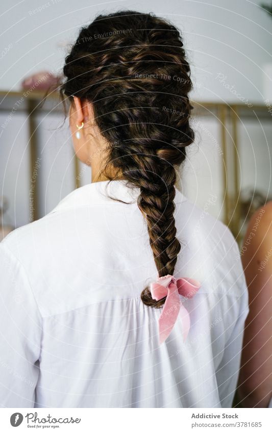 Woman with creative hairstyle in studio salon woman braid hairdo ribbon tender elegant client female bright professional trendy luxury treat customer