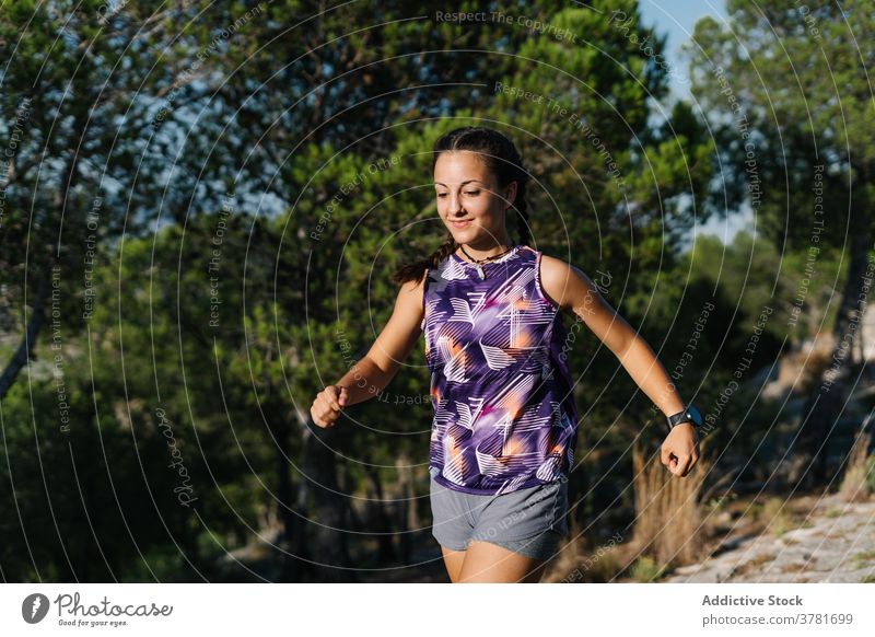 Active woman running on trail in forest mountain active workout training sport athlete positive young female nature fitness lifestyle activewear sportswear