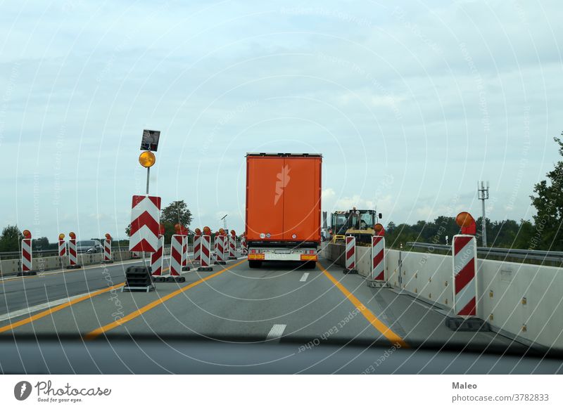 A truck drives through a construction site on the highway building road business car people industrial industry safety transport transportation vehicle work