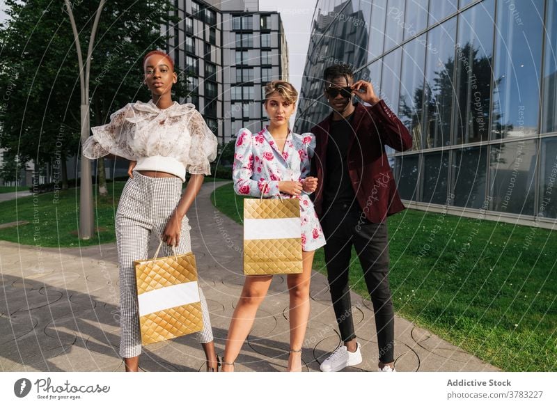 Young fashionable people with shopping bags on street style group trendy outfit urban shopper customer confident contemporary together friend youth young ethnic
