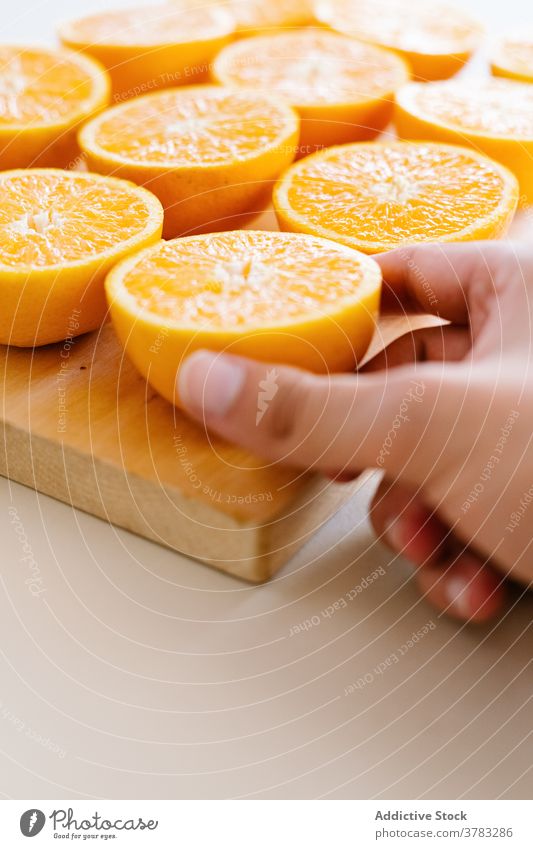Crop person with oranges on cutting board half arrangement line order row studio fruit wooden ripe vegetarian food chopping board fresh nutrition diet natural