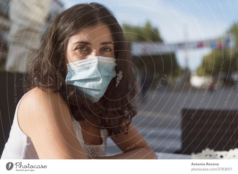Pretty woman in bar terrace with face mask looking at camera covid-19 coronavirus pollution allergy surgical person people one person protective surgical mask