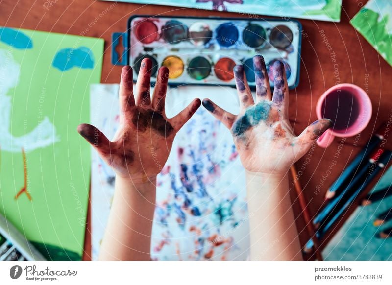 Little girl preschooler showing painted colourful hands child painting dye education colorful art home paper childhood creation craft table creativity kid