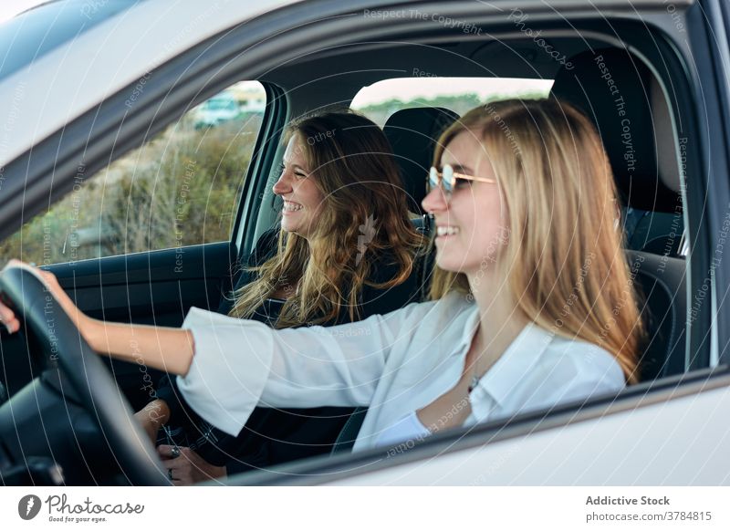 Carefree traveling women in car road trip seaside together friend ride drive summer vacation journey holiday enjoy nature adventure vehicle smile sit cheerful