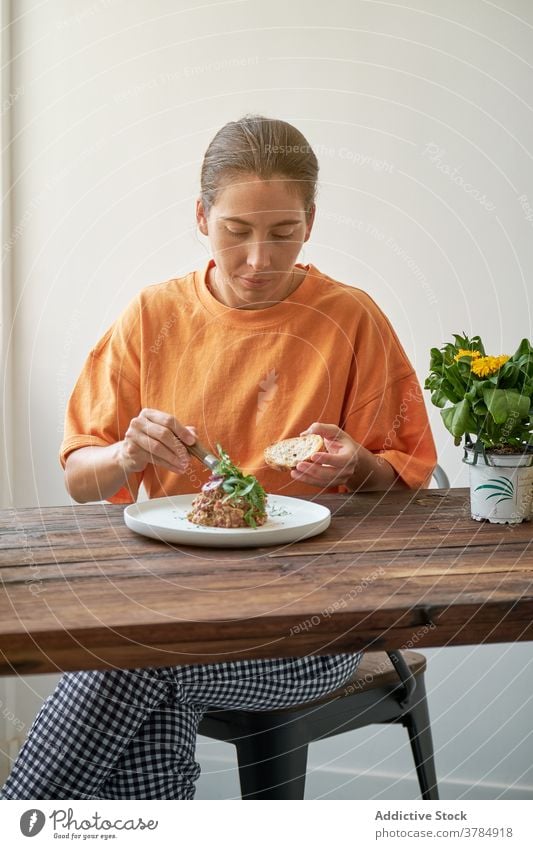 Pensive woman having tasty lunch at home steak tartare eat enjoy dish delight sitting female plate table happy gourmet healthy nutrition relax lady pleasure