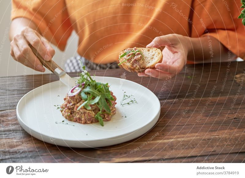 Pensive woman having tasty lunch at home steak tartare anonymous eat enjoy dish delight sitting female plate table happy gourmet healthy nutrition relax lady
