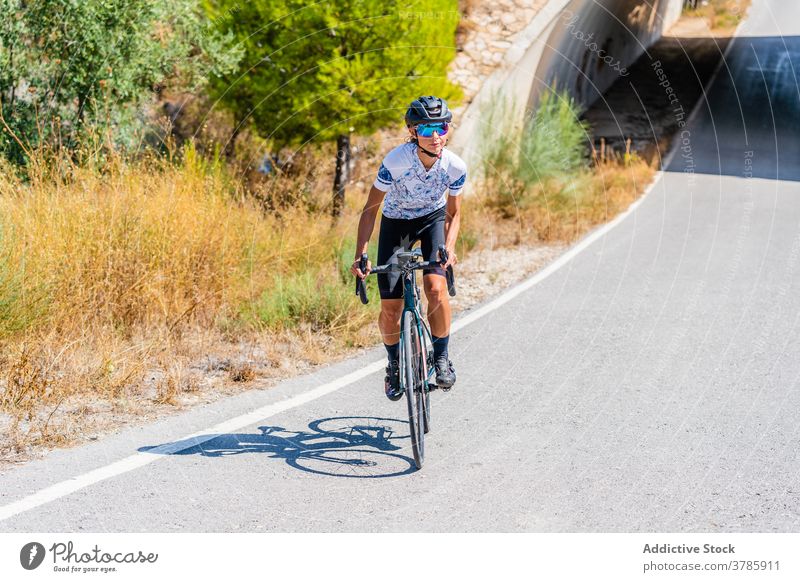 Cyclist riding bike on rural road in highlands cyclist ride mountain bicycle active sport route workout nature woman lifestyle activity healthy summer adventure