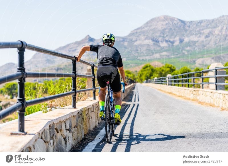 Sportive cyclist resting during ride on mountain road bike bicycle active sport training lifestyle endurance activity healthy summer adventure route trip