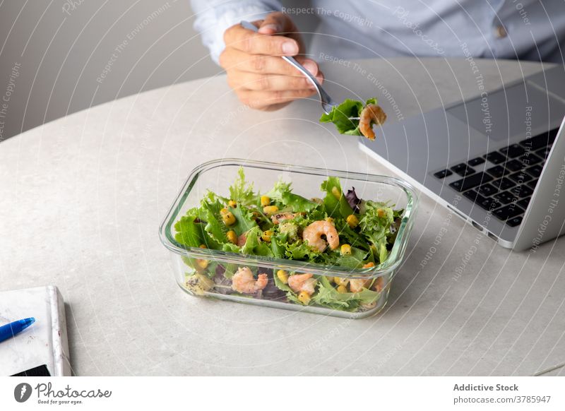 Crop worker having lunch in office eat workplace food salad nutrition healthy food employee table delicious lunch box tasty dish greenery snack sit desk meal