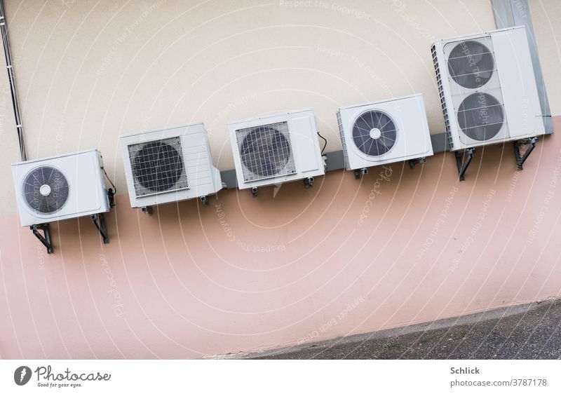 Climate conference hangs crooked, several heat exchangers of energy-consuming air conditioning systems mounted on a pink wall climate conference symbolic