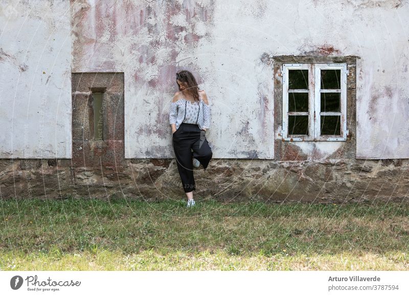 Woman leaning on the facade of an old house with white wall and some classic windows summer woman girl caucasian rest freedom autumn wooden portrait relax