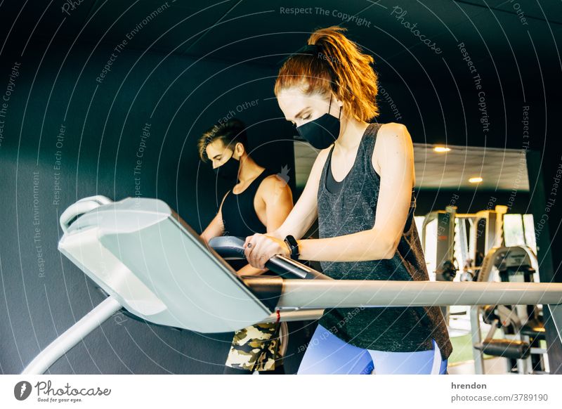 a young woman and a young man wearing a face mask work out at the gym person group sport fit health training healthy club exercising working workout athletic
