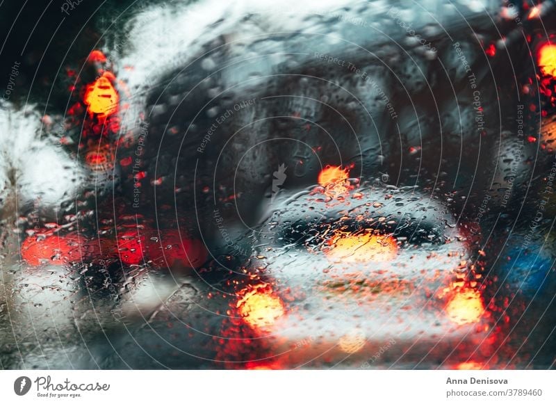 Blurred city street during dark rainy day blur blurry bokeh blurred background urban scene car motion abstract road downtown traffic light outdoor cityscape