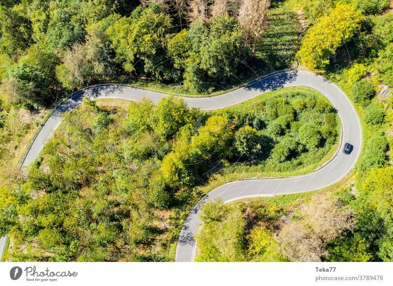 a car on a curvy forest road from above car from above forest from above street from above concrete summer countryside transportation sun shadow