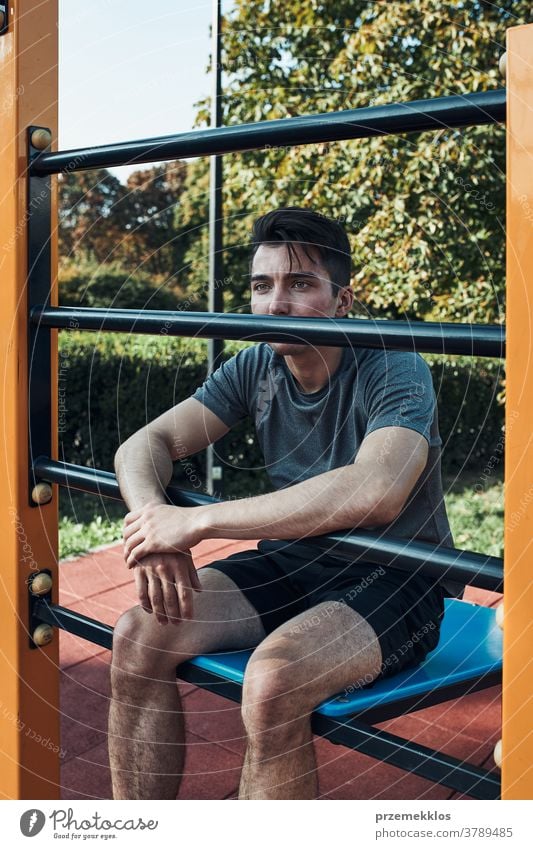 Portrait of young man having break during his workout in a modern calisthenics street workout park care caucasian health lifestyle male one outdoors person