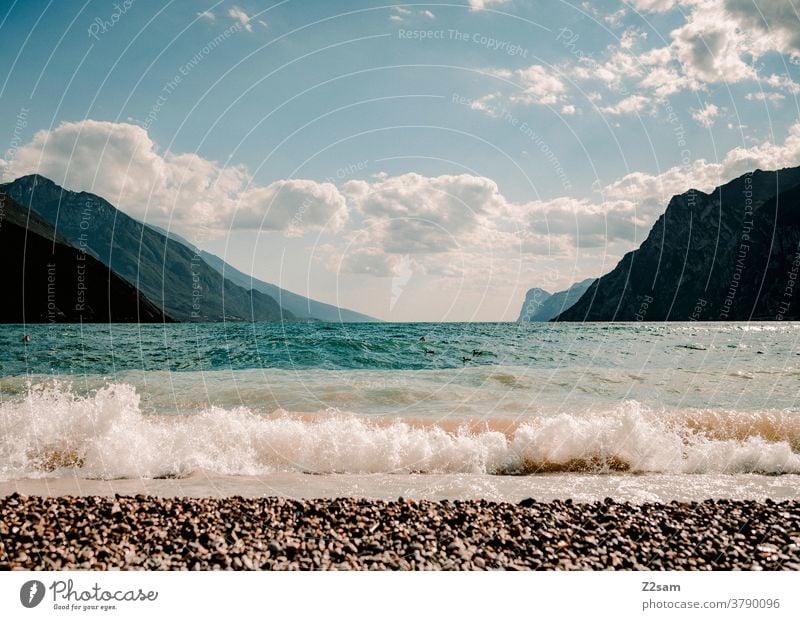 Wellen am Gardsee gardasee norditalien torbole urlaub wellen wasser gewässer frisch strand alpen berge wolken himmel blau ferien sommer sonne gischt Landschaft