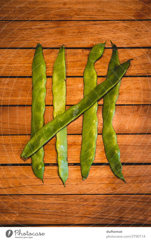 Five green beans lying on a wooden table Bean Numbers runner beans Green five Nutrition Macro (Extreme close-up) Structures and shapes 5 structure Swab