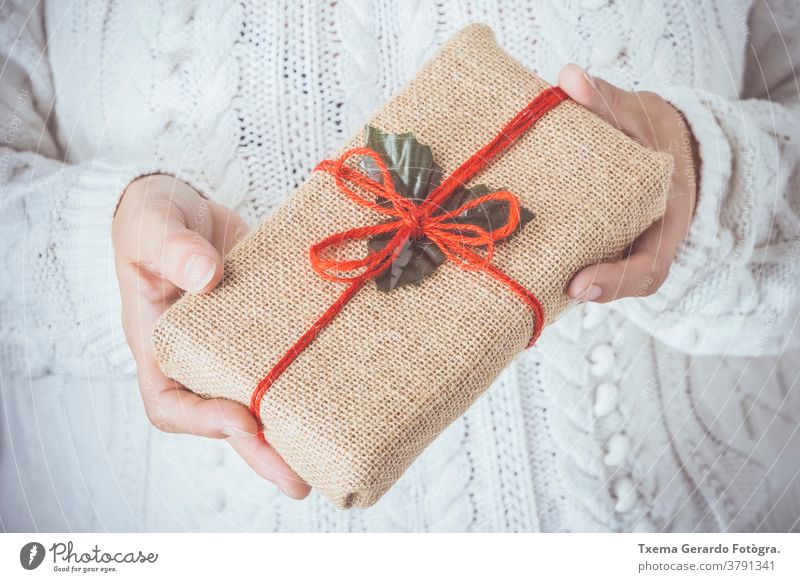 Woman hands holding a Christmas present decorated in a rustic box christmas handmade hipster white background card holiday december matte vintage woman