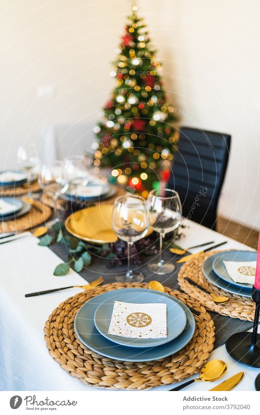 Dining table served Christmas celebration near shining Christmas tree christmas setting celebrate festive banquet december decoration eve merry party holiday