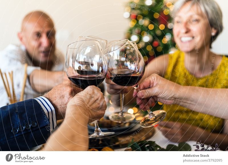 Cheerful friends with red wine during Christmas celebration at home cheers glass celebrate happy christmas food festive dinner gather table alcohol drink