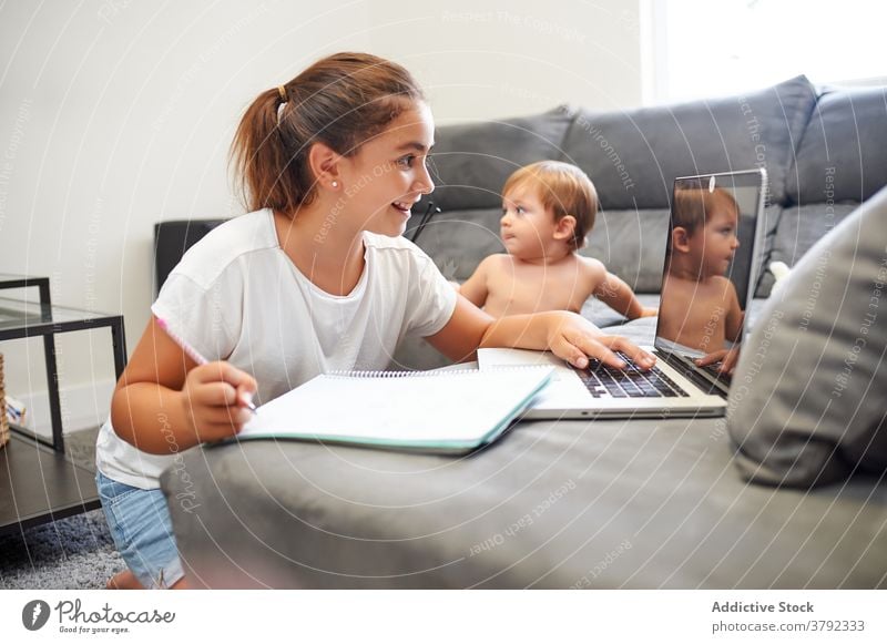 Sister and brother relaxing at home and using netbook watch cartoon sibling together laptop boy girl choose sofa peaceful browsing device rest online couch